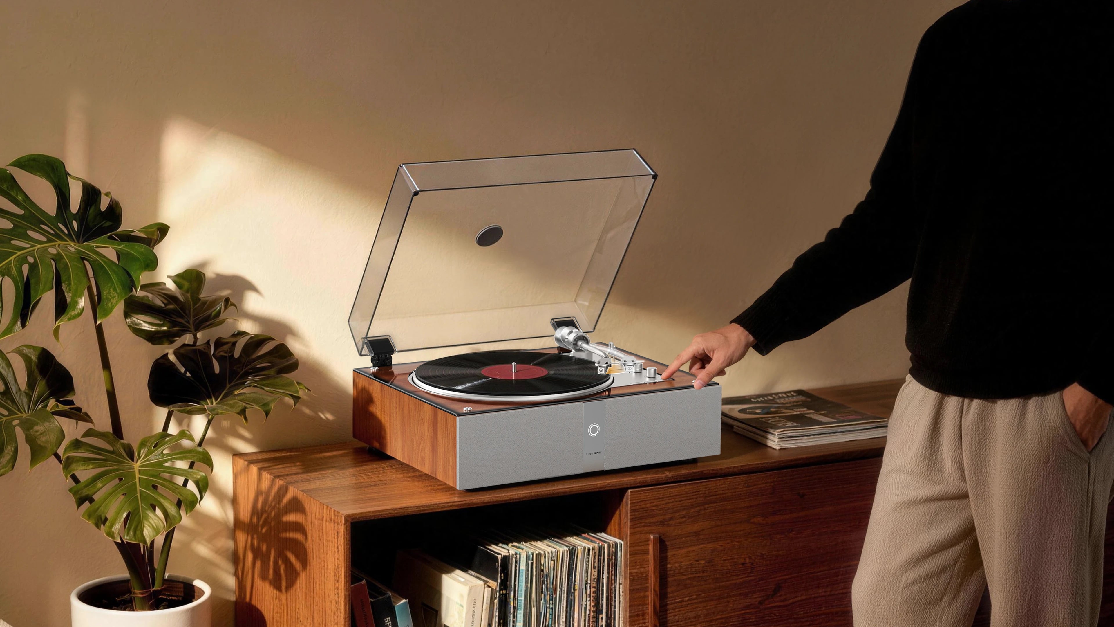 Hand activating the fully automatic turntable start button for a seamless analog listening experience. 