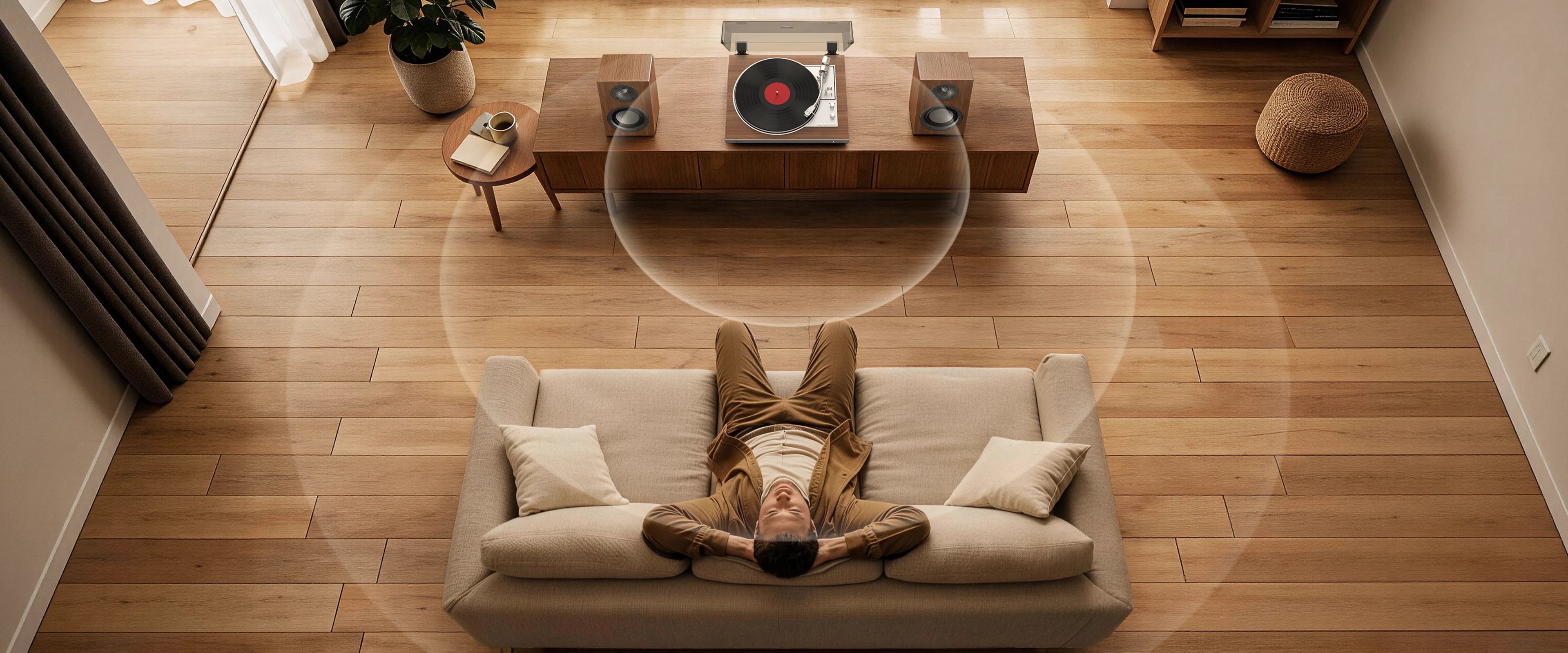 Man on sofa enjoying a wooden record player, illustrating a record player with speakers audio experience.