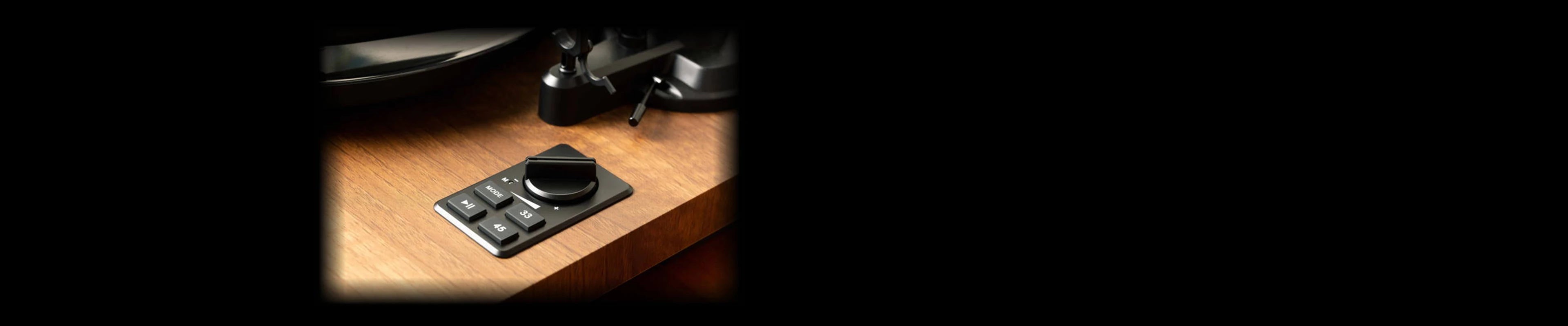 Close-up of the wood plinth controls on a bluetooth record player.