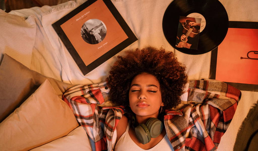Woman relaxing with vinyl beside a top-down mahogany bluetooth turntable for old records on a fur rug