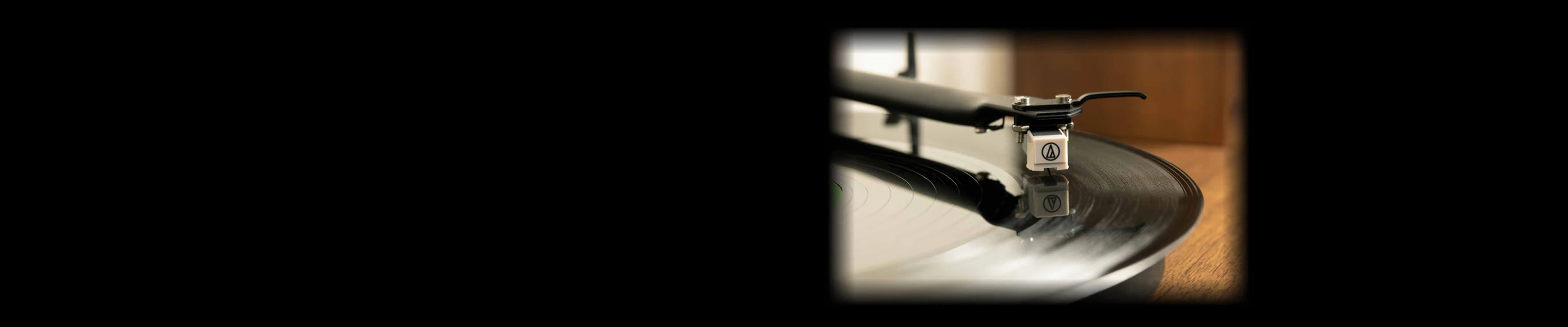 Close-up of a premium phono cartridge tracing a spinning vinyl.