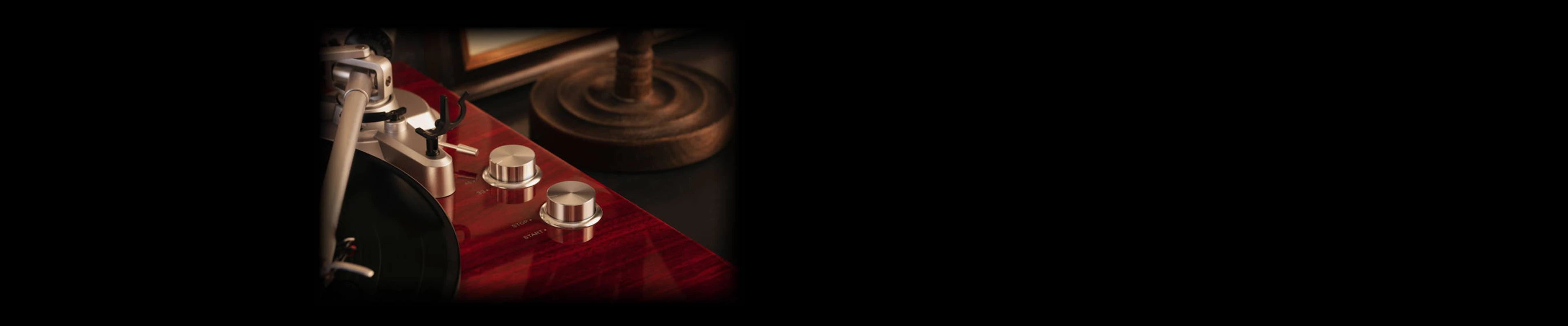 Silver speed and start-stop control knobs on the mahogany turntable record player