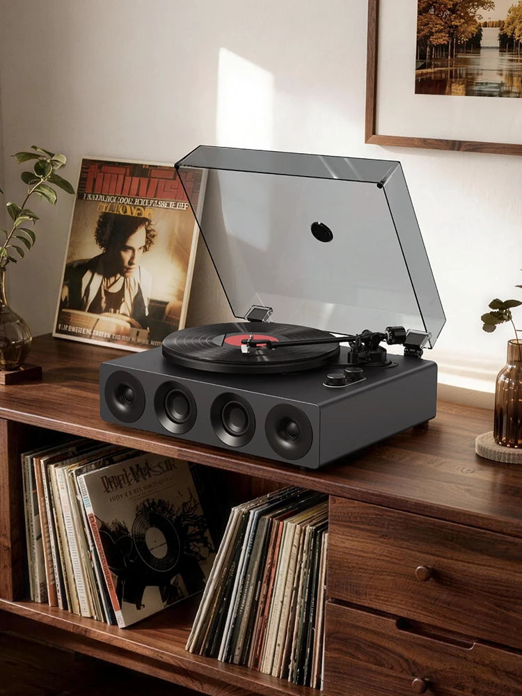 A modern record player with built-in speakers on a vintage wooden cabinet with vinyls in home office. 