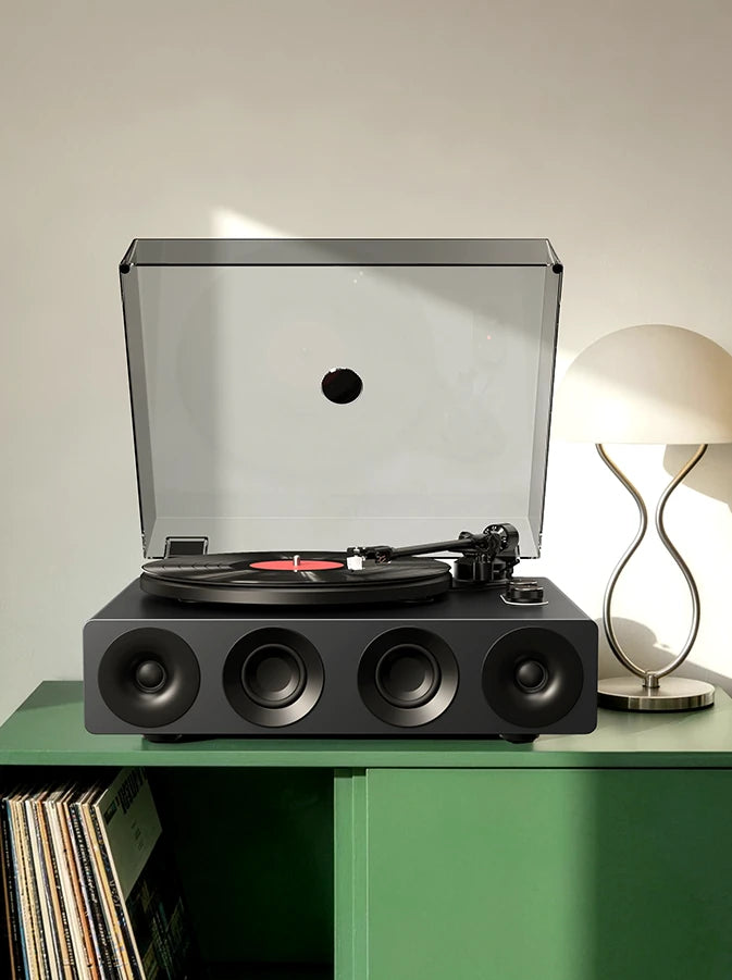 Grey all-in-one bluetooth record player on a green vinyl stand with vinyl storage.