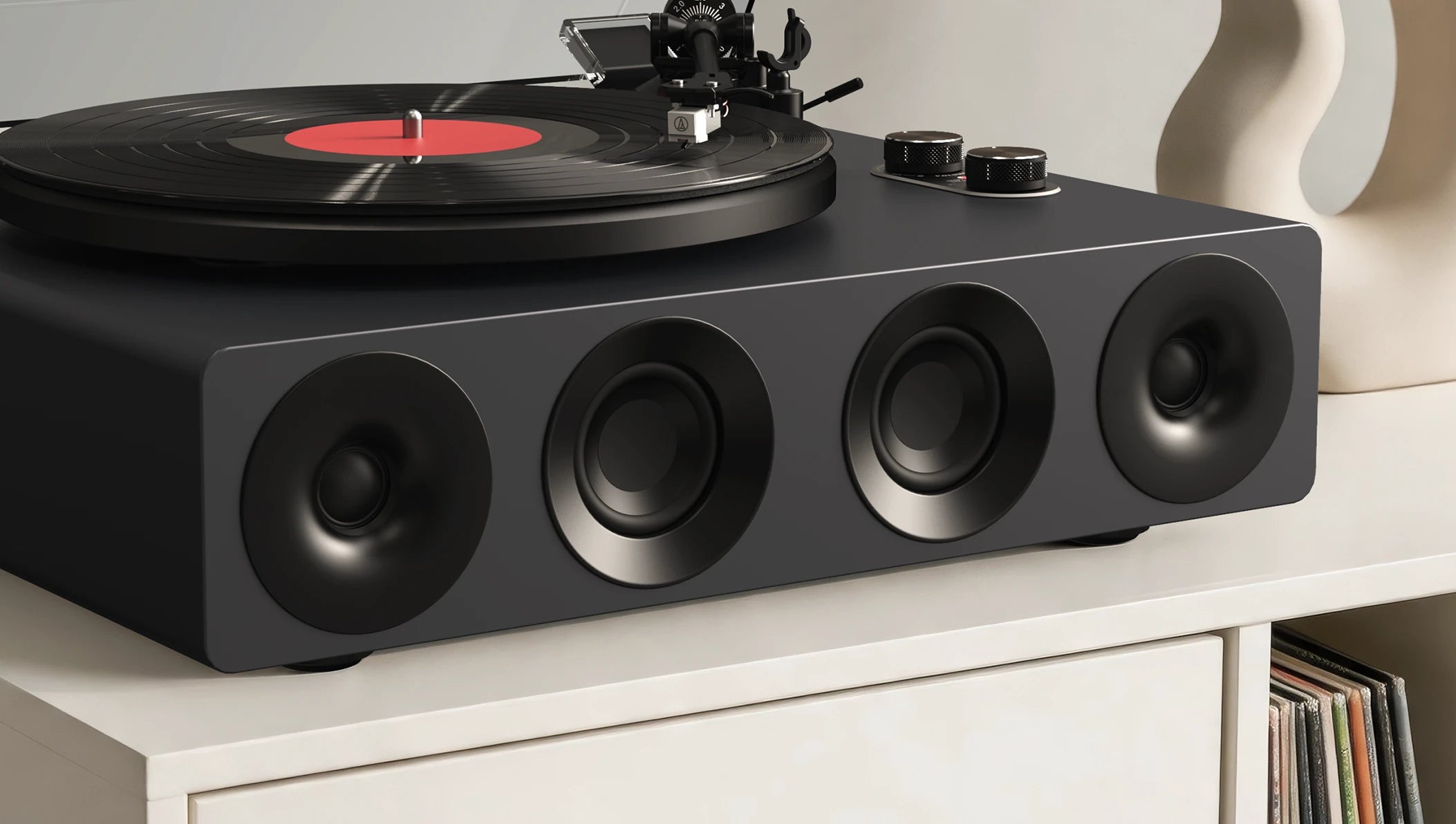 Front view of a modern record player with built-in speakers on a white vinyl stand