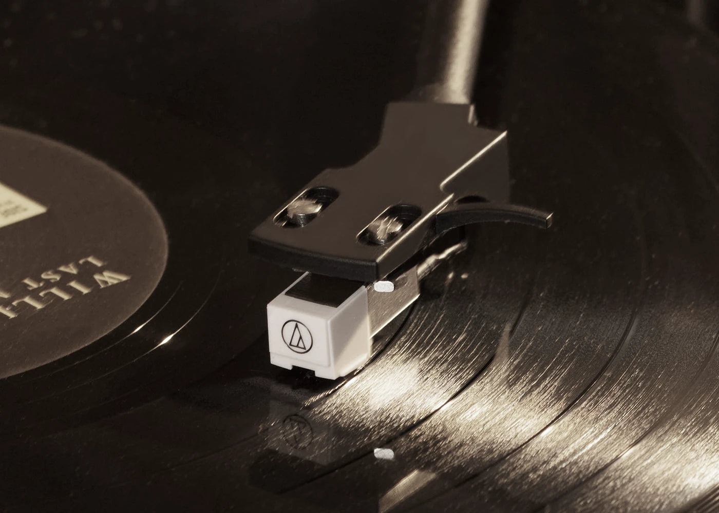 Close-up of a stylus on the Audio-Technica phono cartridge playing a vinyl record