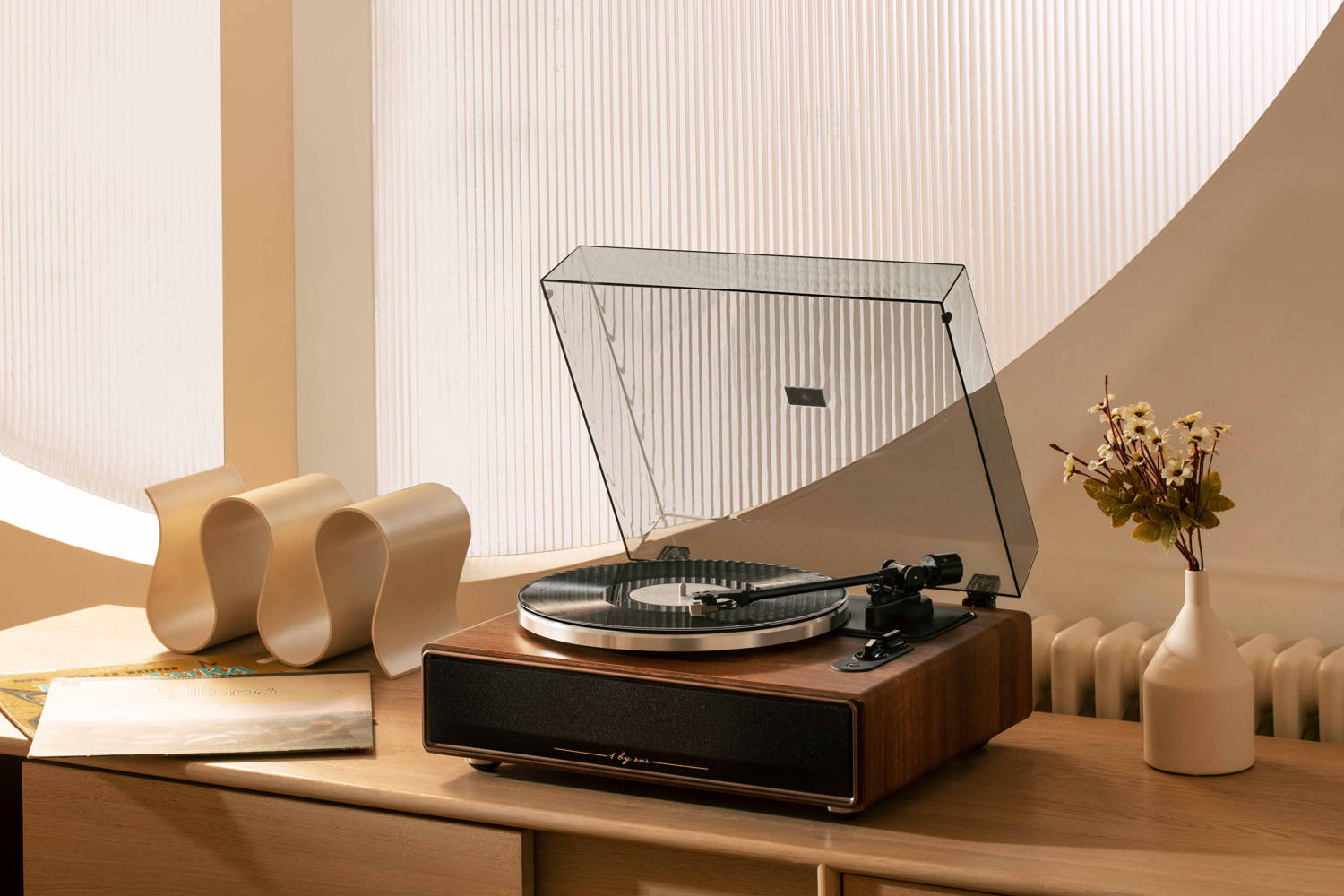 An all in one record player in a warm room, highlighting a premium wooden record player with built-in speakers design.