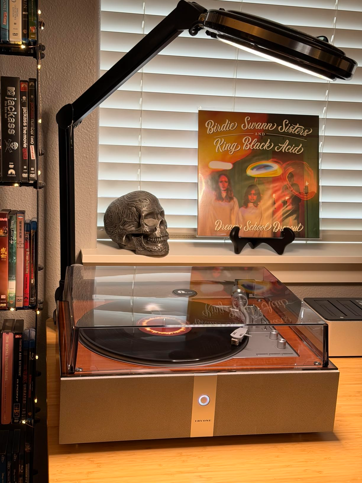  A wood turntable finish on an automatic record player placed on a home office desk creates a focused analog listening environment.